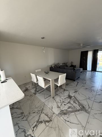 Rotonda West apartment for rent - A living room with a grey couch and a marble floor.