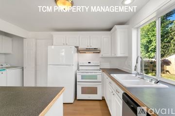 Tacoma house for rent - A kitchen with white appliances and cabinets is available for rent.
