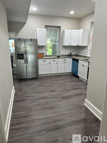 Baltimore house for rent - A kitchen with white cabinets and a grey floor.