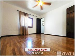 Upland house for rent - A room with wooden flooring and curtains on the windows.