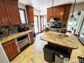 Upland house for rent - A kitchen with wooden cabinets and a granite countertop.