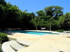 Upland house for rent - A pool surrounded by trees and a concrete patio.