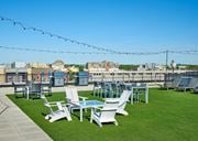 Washington apartment for rent - A patio with white chairs and a table is set up on a grassy area.