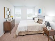 Herndon apartment for rent - A bedroom with a bed, nightstand, and a dresser with a mirror.