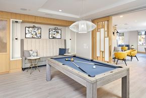 Fairfax apartment for rent - A pool table is in the middle of a room with a chair and a couch.