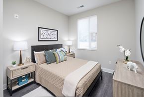 Fairfax apartment for rent - A bedroom with a large bed and a nightstand with a lamp.