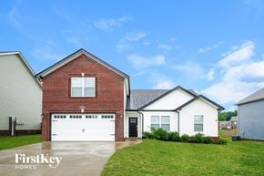 Clarksville house for rent - A house with a red brick exterior and a white garage door is shown.