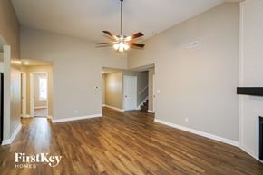 Clarksville house for rent - A spacious room with wooden floors and a ceiling fan.