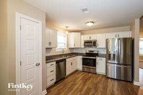 Clarksville house for rent - A kitchen with a stainless steel refrigerator, oven, and microwave.