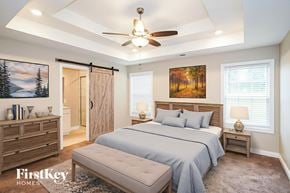 Clarksville house for rent - A bedroom with a bed, nightstands, and a ceiling fan.