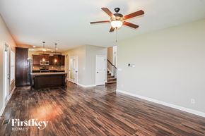 Clarksville house for rent - A spacious room with a ceiling fan and wooden flooring.