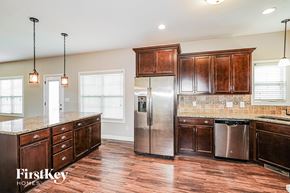 Clarksville house for rent - A kitchen with wooden cabinets and a stainless steel refrigerator.
