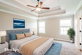 Clarksville house for rent - A bedroom with a large bed and a ceiling fan.