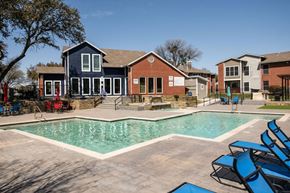 Irving house for rent - A swimming pool surrounded by blue lounge chairs and a building in the background.