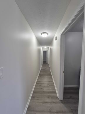 Oak Grove house for rent - A long hallway with white walls and wood flooring.