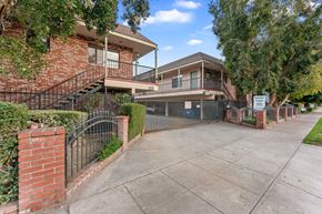 Burbank apartment for rent - A house with a red brick exterior and a black metal fence.