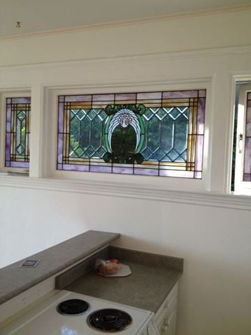 Victoria apartment for rent - A kitchen with a stove and a window with a stained glass design.