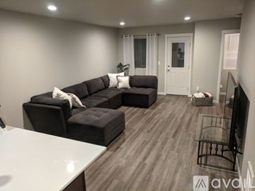 Tacoma house for rent - A modern living room with a large sectional sofa and a flat-screen TV.