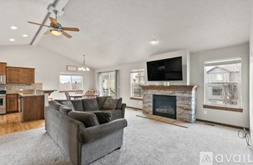 Greenacres house for rent - A living room with a grey couch and a fireplace.
