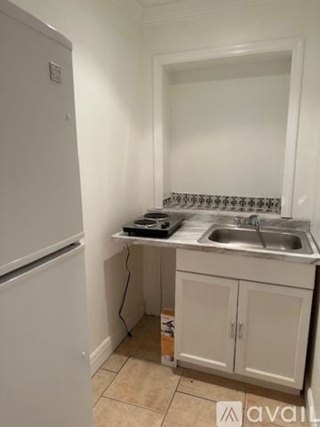 Miramar house for rent - A kitchen with a white fridge, a sink, and a countertop.