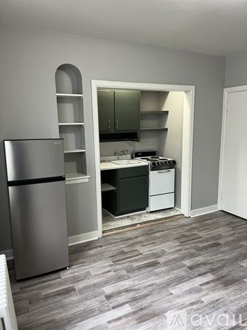 Wauwatosa apartment for rent - A kitchen with a refrigerator and a stove top oven.