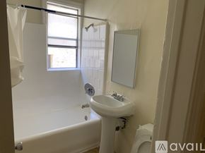 Los Angeles apartment for rent - A bathroom with a white tub, sink, and mirror.