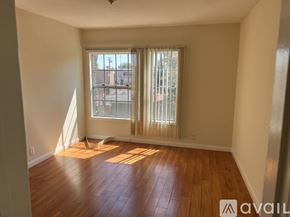 Los Angeles apartment for rent - A room with wooden floors and a window with blinds.