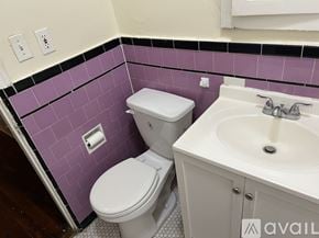Los Angeles apartment for rent - A white toilet and sink in a purple tiled bathroom.