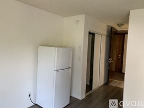 Los Angeles apartment for rent - A white refrigerator in a room with a wooden floor.