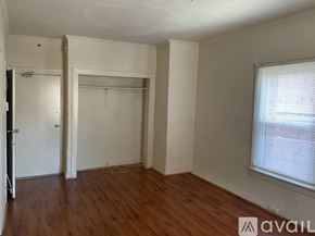 Los Angeles apartment for rent - A room with wooden floors and white walls, with a window on the right side.