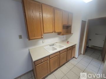 La Crosse apartment for rent - A kitchen with wooden cabinets and a white sink.