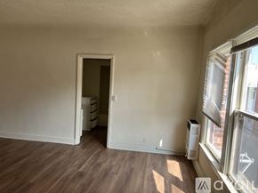 Los Angeles apartment for rent - A room with a doorway leading to another room, a window with blinds, and a floor heater.