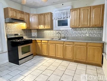 Providence apartment for rent - A kitchen with wooden cabinets and a black stove top oven.