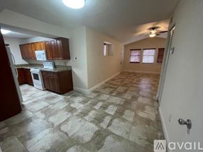 Miami apartment for rent - A kitchen with a tile floor and a ceiling fan.