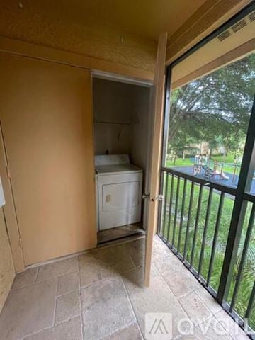 Miami apartment for rent - A small white refrigerator is in a kitchen with a door open.