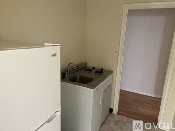Los Angeles apartment for rent - A small kitchen with a white fridge, sink and cabinets.