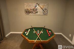 Colorado Springs townhouse for rent - A pool table with a green felt top and white balls is in the center of the image.