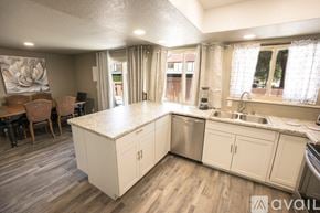 Colorado Springs townhouse for rent - A kitchen with white cabinets and a wooden floor.