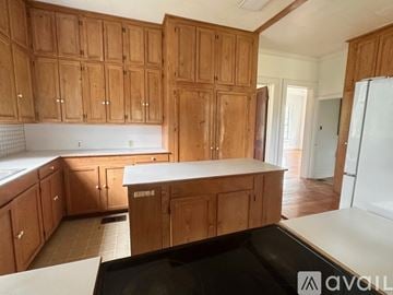 Abbeville house for rent - A kitchen with wooden cabinets and a white countertop.