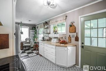 Knoxville house for rent - A kitchen with white cabinets and a black and white checkered floor.