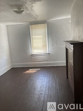 Pittsburgh apartment for rent - A room with wooden floors and a window with blinds.