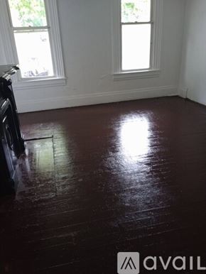 Pittsburgh apartment for rent - A room with dark wood flooring and two windows.