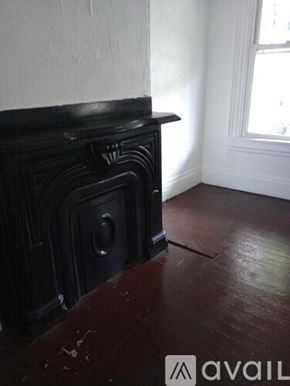 Pittsburgh apartment for rent - A black fireplace in a room with wooden floors.