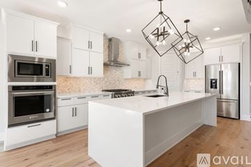 Austin house for rent - A modern kitchen with white cabinets and stainless steel appliances.