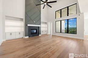 Austin house for rent - A spacious living room with a fireplace and a ceiling fan.