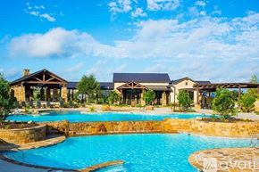 Austin house for rent - A large swimming pool in front of a resort-style building.