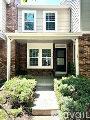 Aurora house for rent - A house with a front porch and a black door.