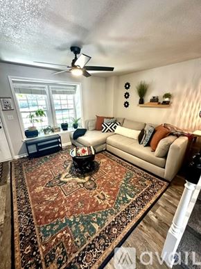 Aurora house for rent - A living room with a rug, a couch, and a ceiling fan.
