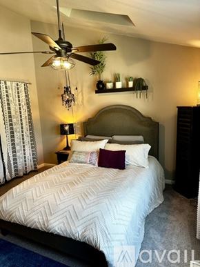 Aurora house for rent - A bedroom with a large bed and a ceiling fan.
