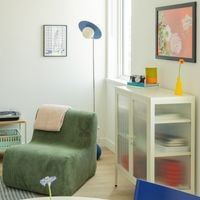 Victoria apartment for rent - A green chair is in the corner of a room with a white cabinet and a picture on the wall.